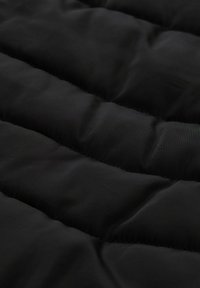 Zwart gebiesd stof met horizontale naden, met een gladde textuur en een subtiele glans, geschikt voor buitenkleding of isolatielagen.