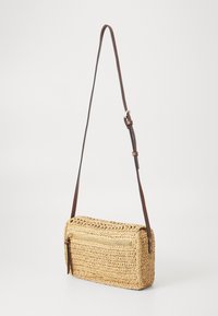 Borsa a tracolla in paglia intrecciata di forma rettangolare, di colore beige, con una tasca con zip. Presenta una tracolla e dettagli in pelle marrone.