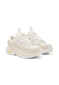 Valkoiset monikerroksiset sneakerit, joissa on tekstuuripinta, joustavat nauhat ja paksu kumipohja, jossa on näkyvät kuvioinnit ja brändiaksentit.