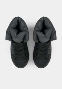 Sneaker alte nere con tomaia morbida e trapuntata, punta rotonda, suola piatta in gomma e design con lacci. Tessuto liscio su tutta la superficie.