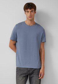 Lichtblauwe katoenen t-shirt met een ronde halslijn en korte mouwen, met een subtiel logo op de borst en een rechte zoom.