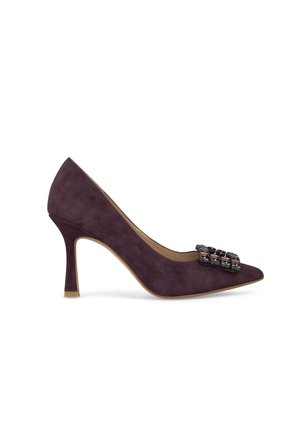 Tacco alto in suede viola con punta affusolata e un ornamento decorativo sul pannello anteriore. Presenta un tacco sottile e un interno beige.
