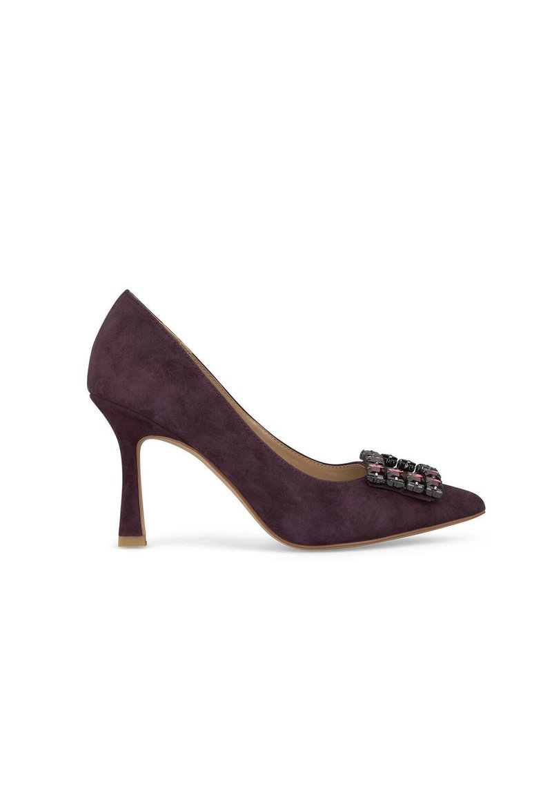 Escarpin en daim violet à bout pointu avec une décoration sur le devant. Présente un talon fin et un intérieur beige.