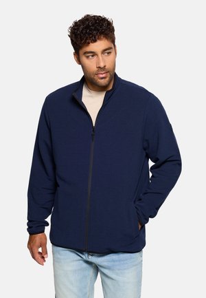 Chaqueta polar azul marino con cremallera, tejido texturizado, cuello alto, bolsillos laterales y cremallera de longitud completa. Ajuste informal con mangas largas.
