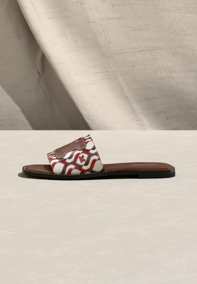 Πλατφόρμα σανδάλι με καφέ σόλα και φαρδιά υφασμάτινη λωρίδα με κόκκινο και λευκό κυματιστό μοτίβο και καφέ διακοσμητικό έμβλημα.