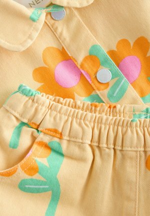 Gul manchestertyg med stora orange och rosa blomster mönster med gröna inslag. Inkluderar en krage och resår i midjan.