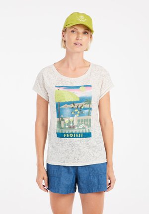 Witte, gestructureerde t-shirt met een kleurrijke, geïllustreerde strandscène met parasols en drankjes. Gecombineerd met blauwe shorts en een groene pet.