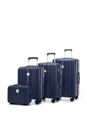 Navy hard-shell luggage set with ribbed texture, extending handles, and multi-directional wheels. Includes four sizes from small to large.
