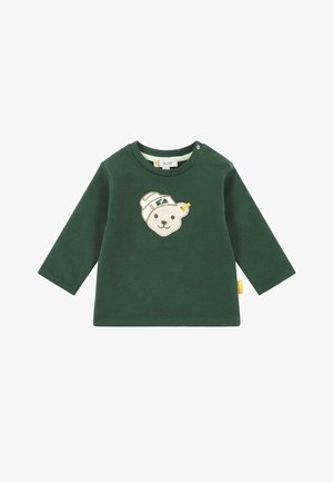 Groene longsleeve shirt gemaakt van zachte stof, met een beige berenapplicatie die een pet draagt. Inclusief schouderknopen voor gemakkelijk aankleden.