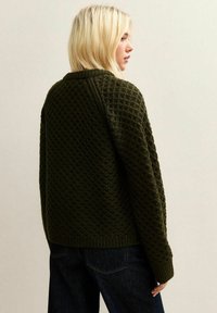 Olijfgroen gebreid truitje met een gestructureerd patroon, geribde manchetten en zoom, ronde halslijn en een boxy, relaxte pasvorm.