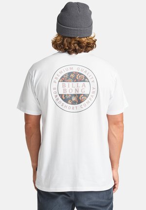 Weißes Baumwoll-T-Shirt mit einem kreisförmigen Grafikdesign, das bunte Blumenmuster zeigt, sowie dem Schriftzug "BILLA BONG" auf dem Rücken. Kurze Ärmel, entspannter Schnitt.