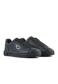 Sneakers in pelle nera con superficie texturizzata, punta tonda e lacci piatti. Presentano un dettaglio del logo in argento e una suola in gomma con pattern antiscivolo.