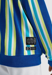 Veste polaire rayée bleu, vert, blanc et turquoise avec un patch logo O'Neill noir et une étiquette de tissu "2/3" sur le bas du dos.