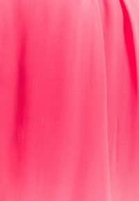 Ljust rosa tyg med en mjuk textur som hänger mjukt. Materialet verkar vara lätt, perfekt för plagg som klänningar eller blusar.