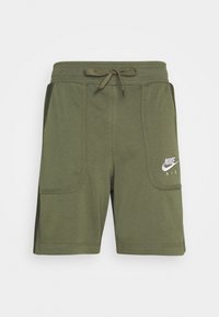 Olivově zelené kraťasy Nike Air s předními kapsami, stažením v pase a bílým vyšitým logem na levé noze.