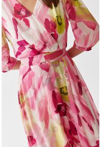 Kwiatowa sukienka o kroju opaski z różowym, żółtym i białym wzorem. Wykonana z lekkiego materiału, z bufiastymi rękawami i dopasowanym paskiem w talii.
