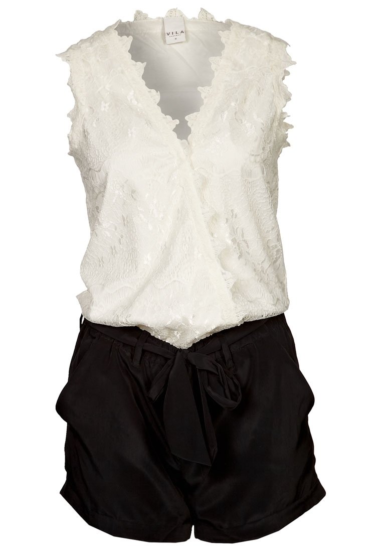 Vit spetsomslagstopp med scallopkanter, kombinerad med svarta shorts med bälte som har ett mjukt, lätt material och avspänd passform.