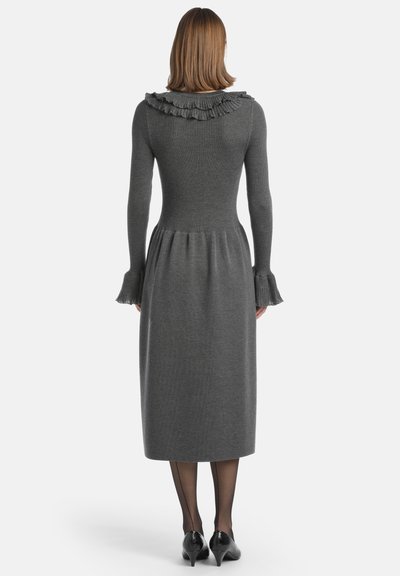 Abito grigio a maglia con scollo a volant, maniche lunghe e fondo svasato. Tessuto testurizzato e dettagli sottili ai bordi delle maniche.