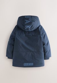 Mørkeblå polstret jakke med hætte, der har et stort "BAKER"-tryk på ryggen, minimalistisk design og glat tekstur.