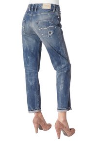 Světlé modré džíny s uvolněným střihem, s dvěma zadními kapsami a ohrnutým lemem, v kombinaci s taupe vysokými podpatky.