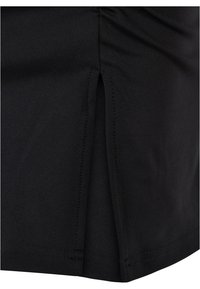 Vêtement en tissu noir avec une texture lisse, présentant un détail de fente sur le côté et des ourlets soigneusement cousus. Pas de motifs ou d'accents supplémentaires.