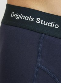 Marineblaue Unterwäsche mit einem breiten schwarzen elastischen Bund, auf dem in weißer Schrift "Originals Studio" steht. Glatte Textur und ausgefallene Nähdetails.