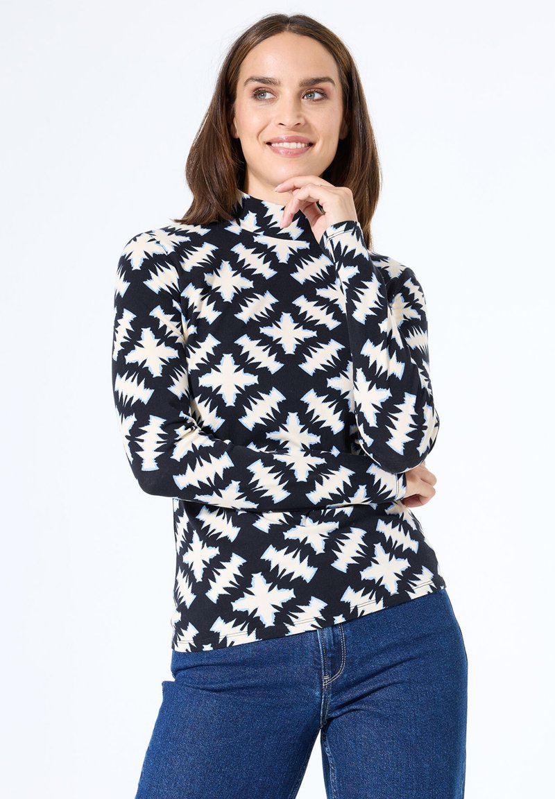 Zwart langemouw turtleneck top met een wit zigzagpatroon. Gemaakt van zachte stof, met een aansluitend ontwerp en een hoge hals.