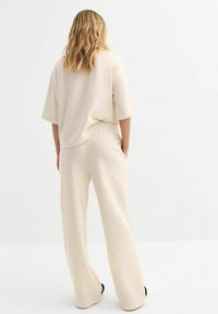 Beige, losvallend top met brede mouwen en bijpassende hoogwaist, brede broek, met een zachte textuur en minimalistisch ontwerp.