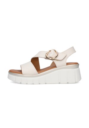 Sandalo con zeppa in pelle beige con cinturini larghi, fibbia circolare dorata e suola spessa bianca texturizzata.