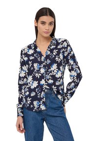 Camicia blu con bottoni, modello floreale in blu e bianco, maniche lunghe e vestibilità rilassata, realizzata in tessuto leggero.