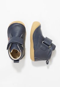 Botas para toddler de cuero azul marino con suela de goma, que cuentan con una correa de Velcro y detalles de costura para mayor durabilidad.