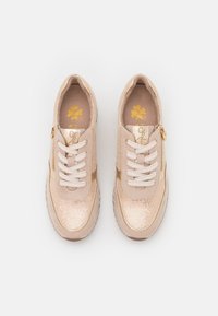 Sneaker casual beige con punte glitterate, lacci bianchi, cerniere laterali e logo scomponibile a quattro foglie dorato all'interno di ogni scarpa.