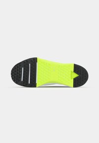 Shoe sole featuring a black rubber base and a bright neon green midsole with a textured triangular pattern for enhanced grip.