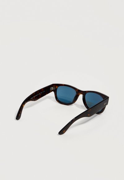 Слънчеви очила Ray-Ban с форма на костенурка и правоъгълни сини стъкла, отворени и поставени върху бяла повърхност.