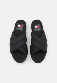 Sandalias negras de tela con un diseño de banda cruzada texturizada. Cuentan con una plantilla acolchada y un parche con el logotipo en la parte superior.