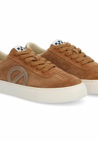 Brown suede sneakers with a smooth texture, featuring a round logo accent, white rubber sole, brown laces, and a checkerboard tag on the tongue.