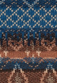 Strickstoff in Blau, Braun und Creme mit geometrischen Mustern; strukturierte Oberfläche mit unterschiedlichen Stricktechniken.