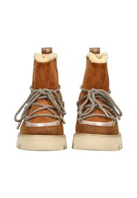 Un paio di stivali in suede marrone per l'inverno con suole bianche spesse, lacci beige a fantasia e una morbida fodera di colore crema nella parte superiore.