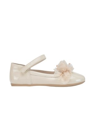 Zapato Mary Jane beige brillante con un lazo de tela en la parte delantera y una correa de velcro en la parte superior.