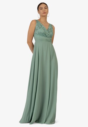 Long green dress featuring a lace bodice, V-neck, and flowing chiffon skirt. Smooth texture with pleats at the waist for structure.