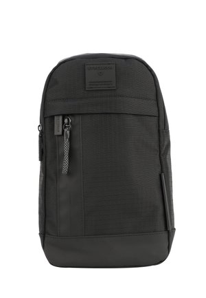 Sort rygsæk med tekstureret stof, en frontlomme med lynlås, et logo-patch og et robust design med en glat bundpanel i kontrast.