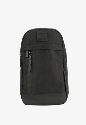 Črn nahrbtnik z teksturirano tkanino, sprednjim žepom na zadrgo, logotipom in trdno zasnovo z kontrastnim gladkim spodnjim delom.