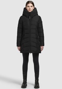 Svart vadderad vinterjacka med hög huva, dragkedjestängning och sidofickor. Funktioner en quiltad design med texturerade sektioner.