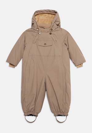 Beige one-piece winter snowsuit with hood, buttoned chest pocket, elastic cuffs, and foot straps for child’s outdoor wear.
