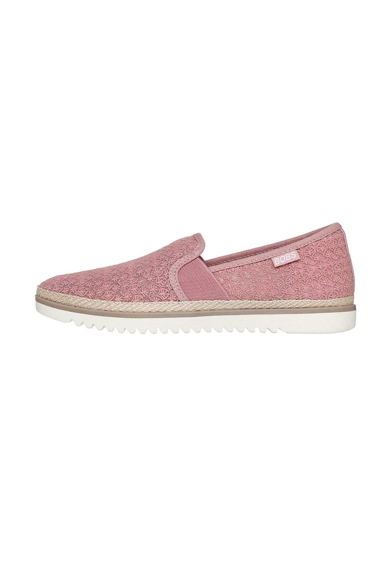 Zapato rosa tipo slip-on con parte superior texturizada, paneles laterales elásticos y suela de goma blanca. Presenta una sutil marca en el costado.