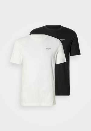 Two cotton t-shirts in white and black. Short sleeves, crew neck, featuring a small logo on the upper left chest area.