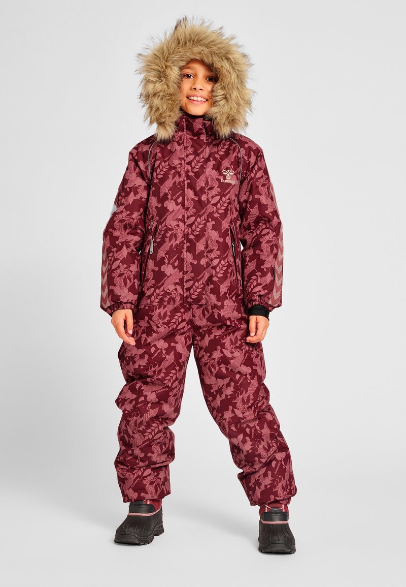 Maroon snowsuit with floral pattern, featuring a fur-lined hood, elastic cuffs, and sturdy black boots. Designed for warmth and mobility.