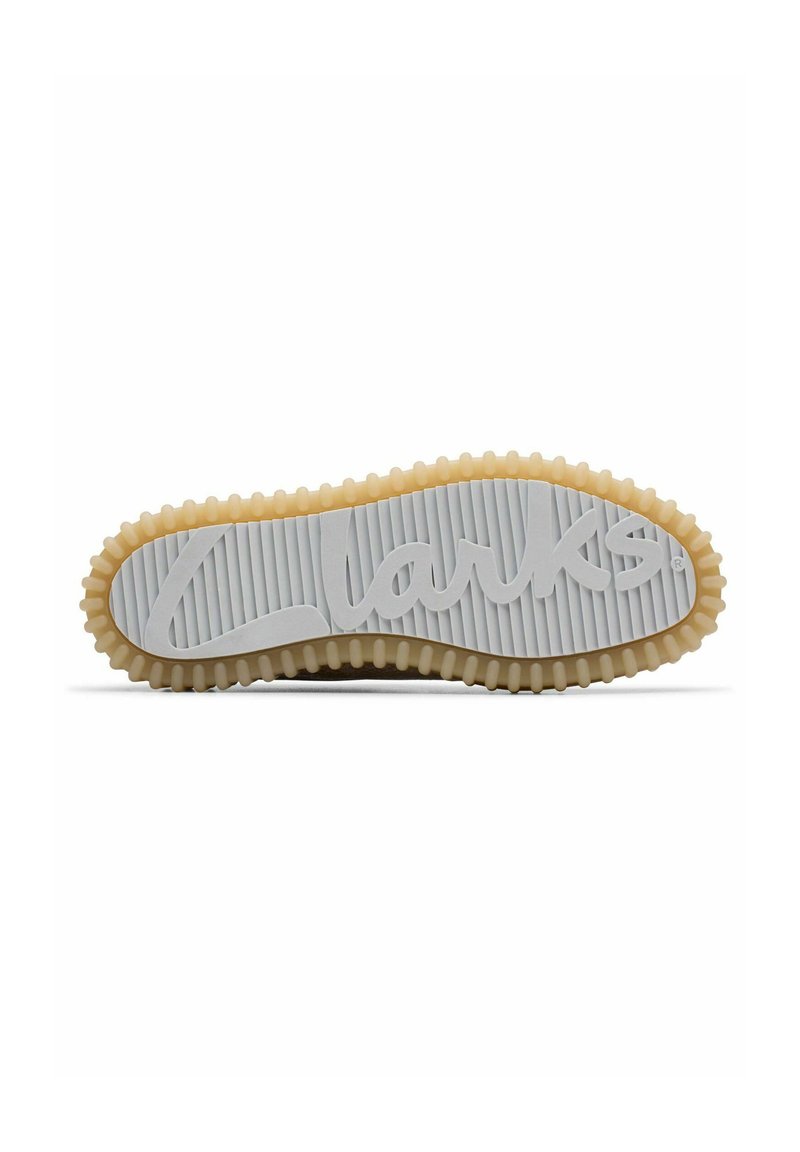 Semelle de chaussure en caoutchouc blanc avec texture nervurée, arborant un logo "Clarks" bien visible. Le bord présente un design beige ondulé et des bosses surélevées.