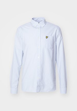 Camisa de botones de manga larga a rayas azules y blancas, con un cuello y un pequeño logo de insecto amarillo en el bolsillo izquierdo del pecho.