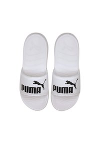 Vita slidesandaler i syntetmaterial med en bred rem som har svart "PUMA"-logotyp och logotypaccent. Texturerad fotbädd.